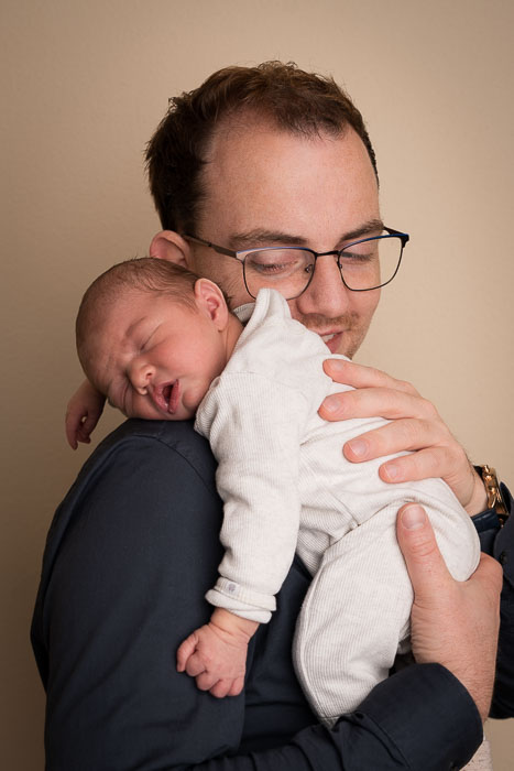 Pasgeboren baby op papa's schouder
