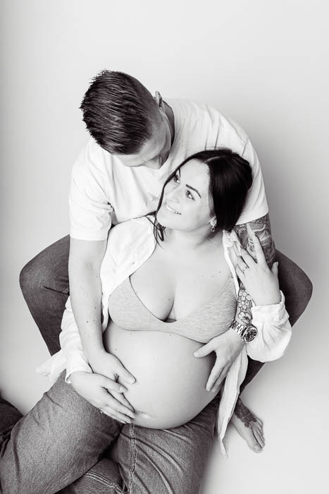 Zwangerschapsshoot van stel bij Studio Suilen. Witte achtergrond. Zwart-wit foto. Zwangerschap fotostudio.